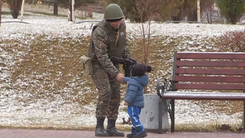 Военный здоровается с малышом Солдат Национальной гвардии
