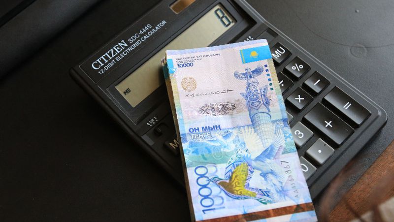 Деньги на калькуляторе зарплата, тенге, оклад