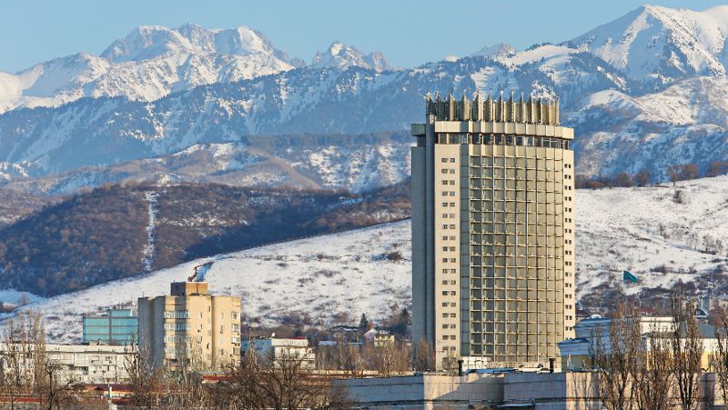 Гостиница "Казахстан" на фоне гор Зимний вид Алматы