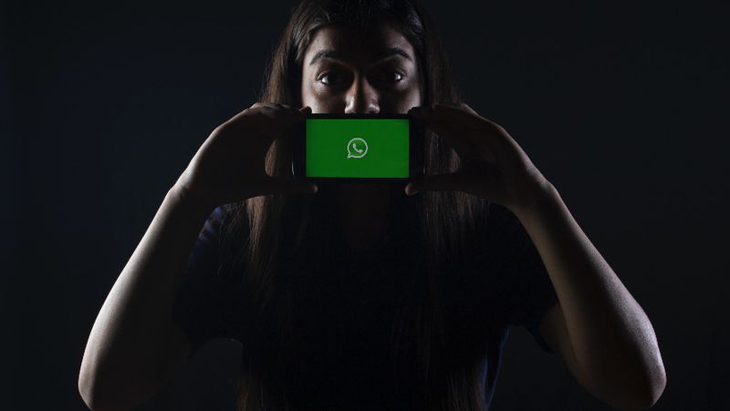 Девушка со смартфоном WhatsApp новая функция